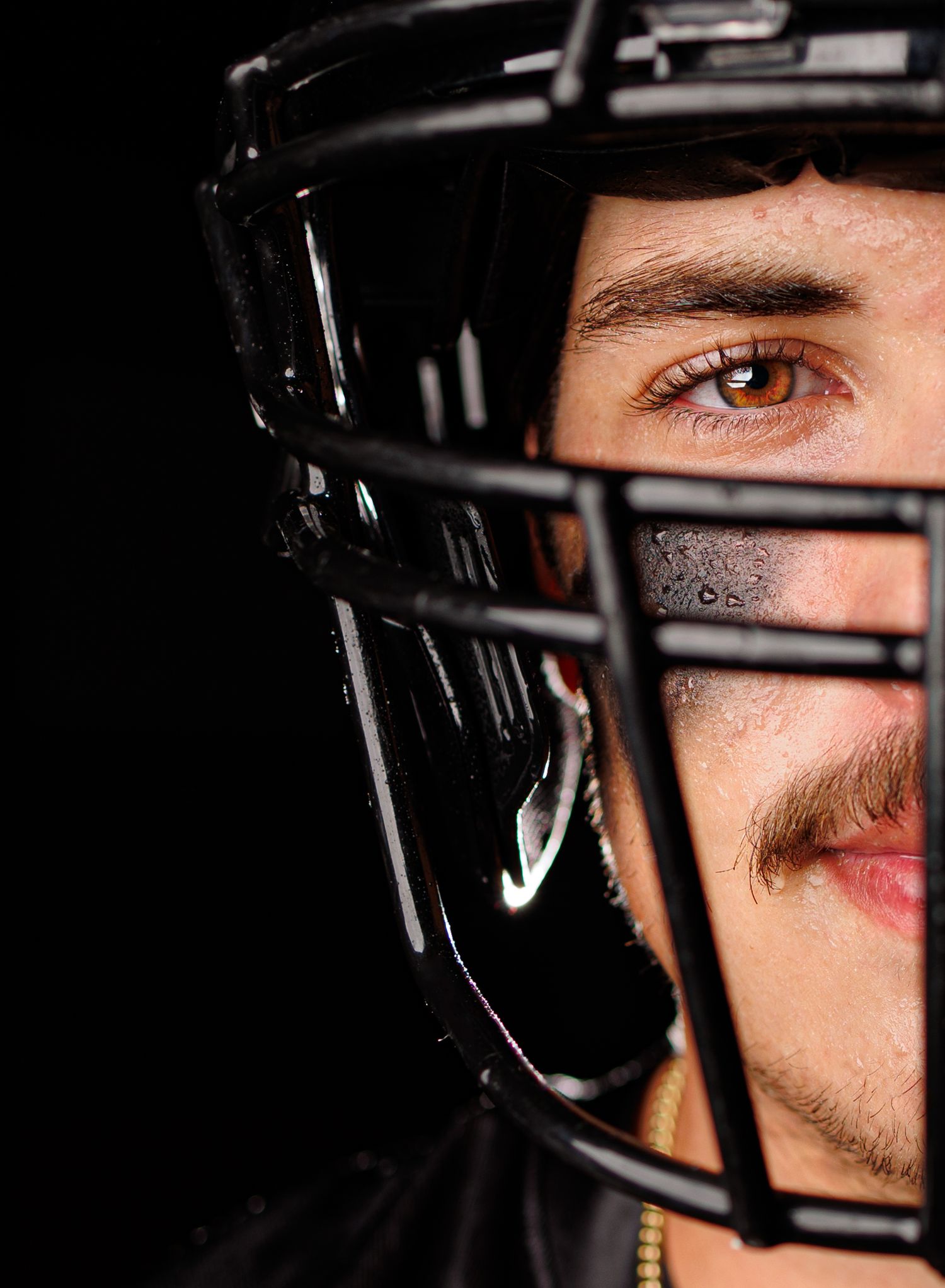 A dramatic close-up series of a senior football player wearing a black helmet