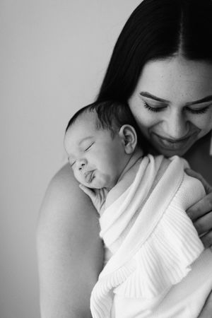 Intimate black and white series showing tender moments between parent and newborn.