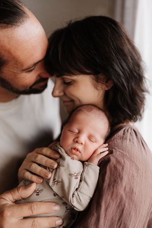 A tender moment captured in a series of intimate family photos showing gentle kisses and loving embraces.