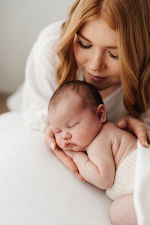 Series of gentle moments between parent and sleeping baby in soft natural light.