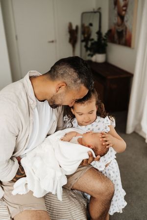 A tender moment between a parent and baby while sitting on a couch.