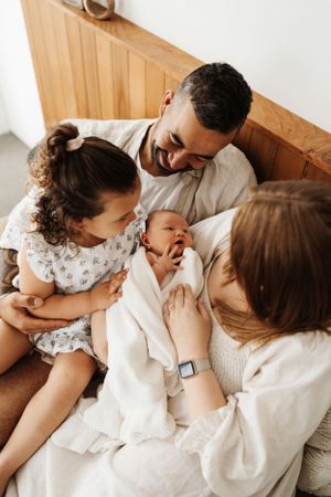 Family sharing intimate moments while relaxing together on wooden furniture.
