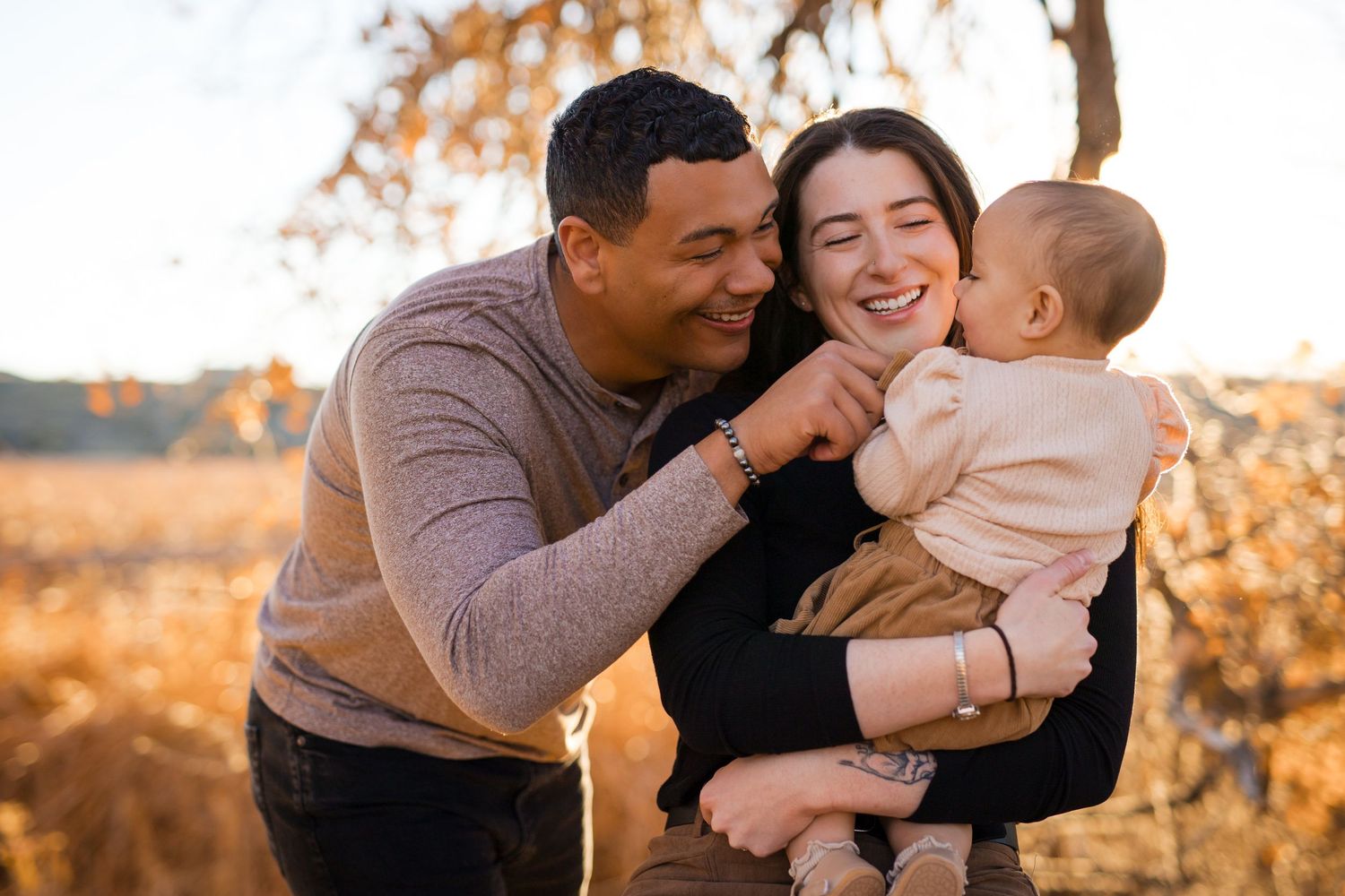 Family shares joyful moments together during golden hour photoshoot in a park setting.