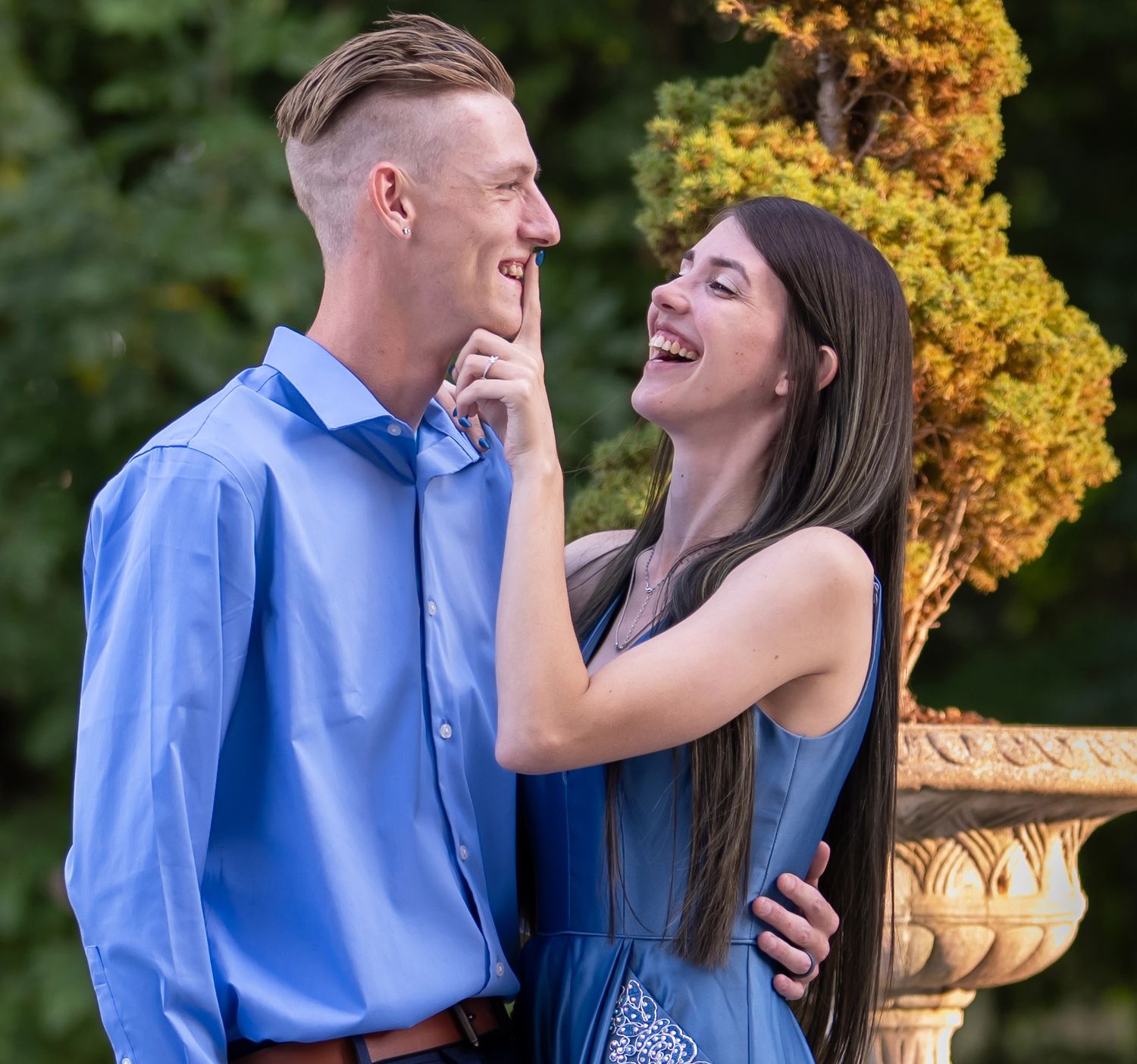 A couple shares joyful laughter together during an engagement photo session
