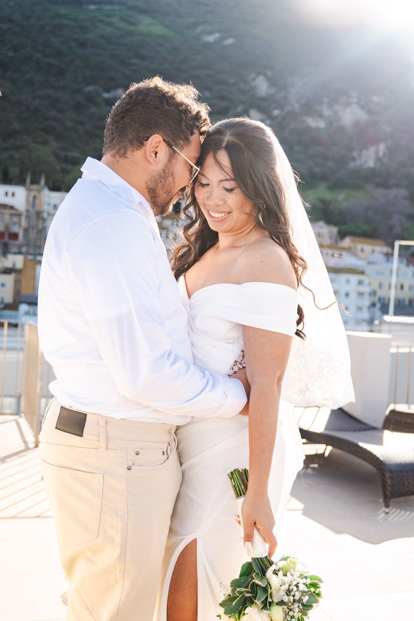 Wedding couple embrace on roof of Elliot hotel in Gibraltar