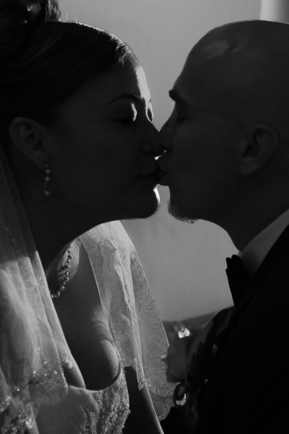 A black and white artistic photo sequence shows a couple in wedding attire sharing an intimate kiss.