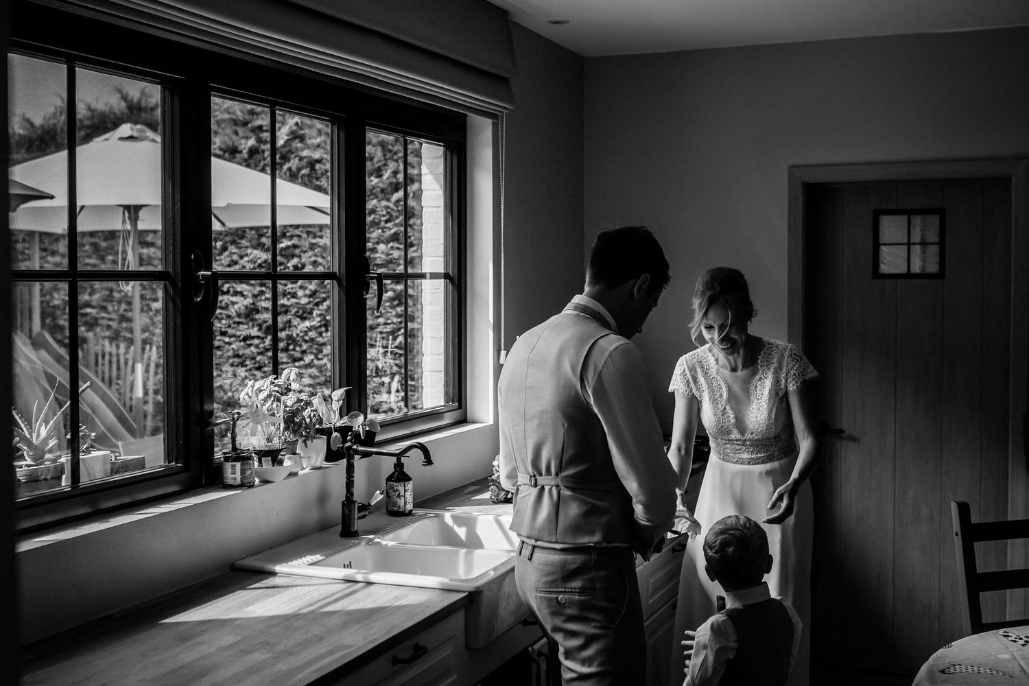 Black and white panoramic photo showing a couple looking out large windows at a mountain landscape view.