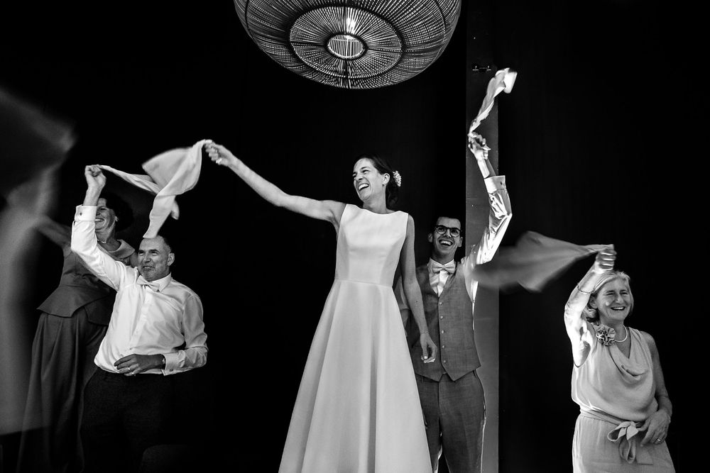 Theater actors performing an energetic scene on a dark stage with dramatic lighting and choreographed movements.