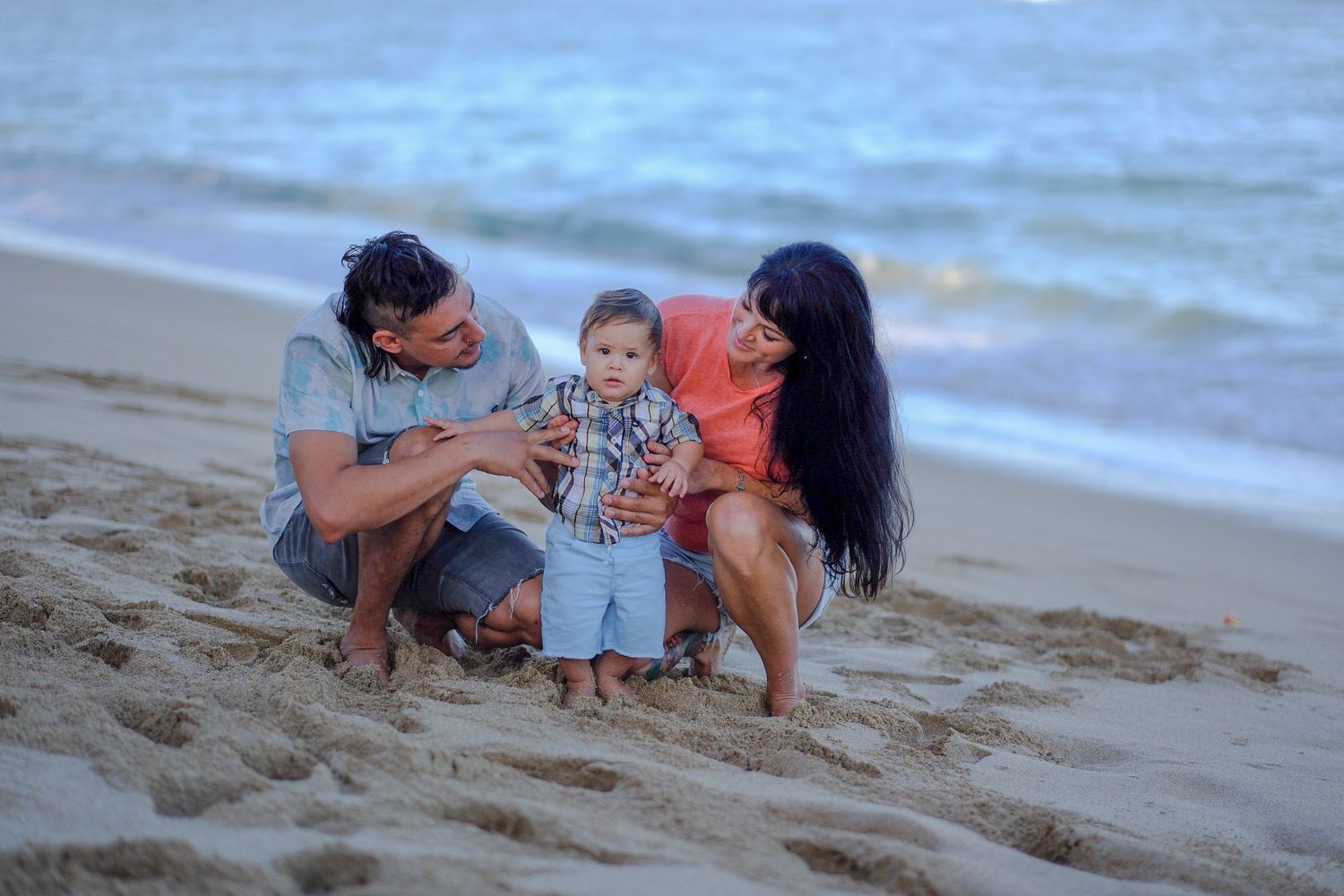 Family sharing a candid moment during a sunset beach photography session on Oahu's North Shore.
