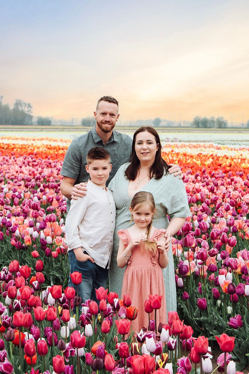 Parents and children enjoying a spring family photoshoot among tulips at The Tulip Barn in the Netherlands by Jorietha Rabie Photography