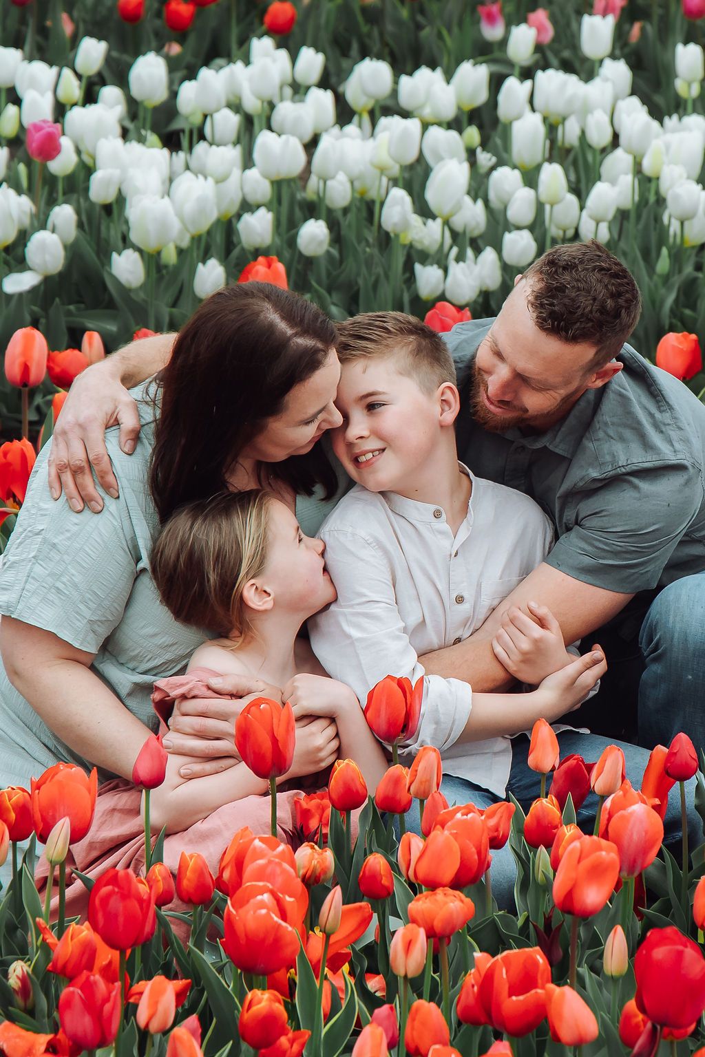 Family enjoying a natural tulip field session at The Tulip Barn, Netherlands, captured by Jorietha Rabie Photography on a cloudy day