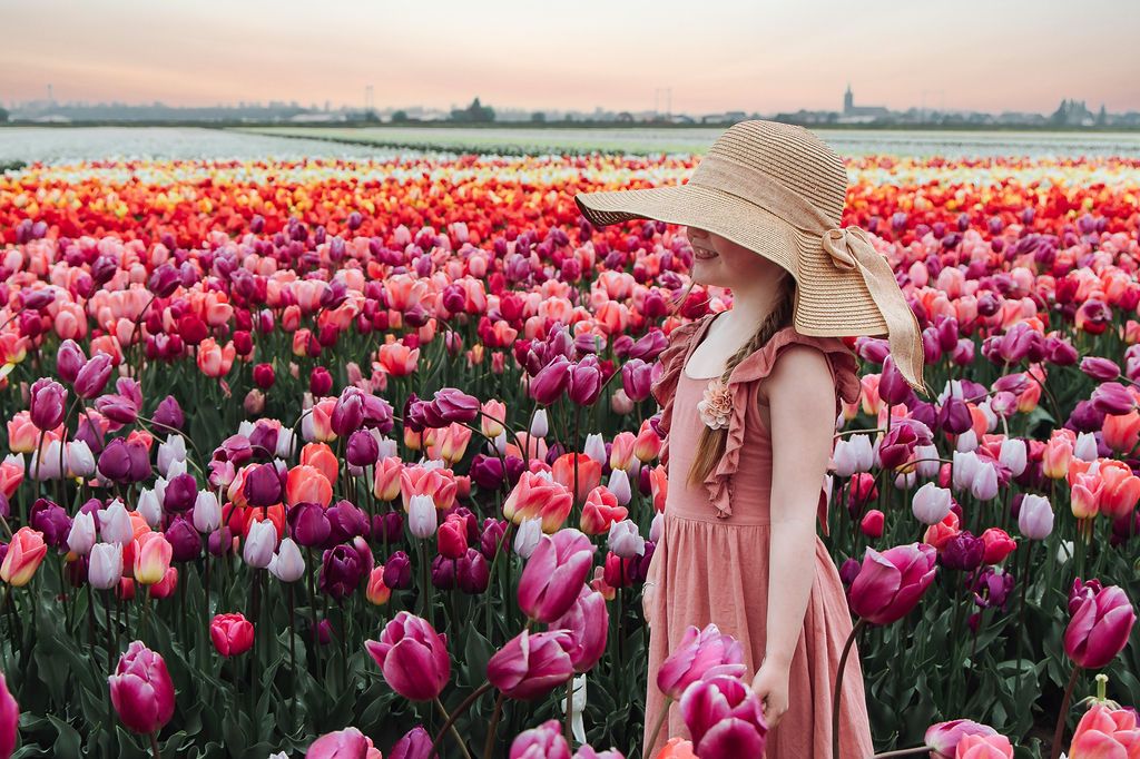 Girl standing in a tulip field in the Netherlands at The Tulip Barn photographed by local photographer Jorietha Rabie Photography