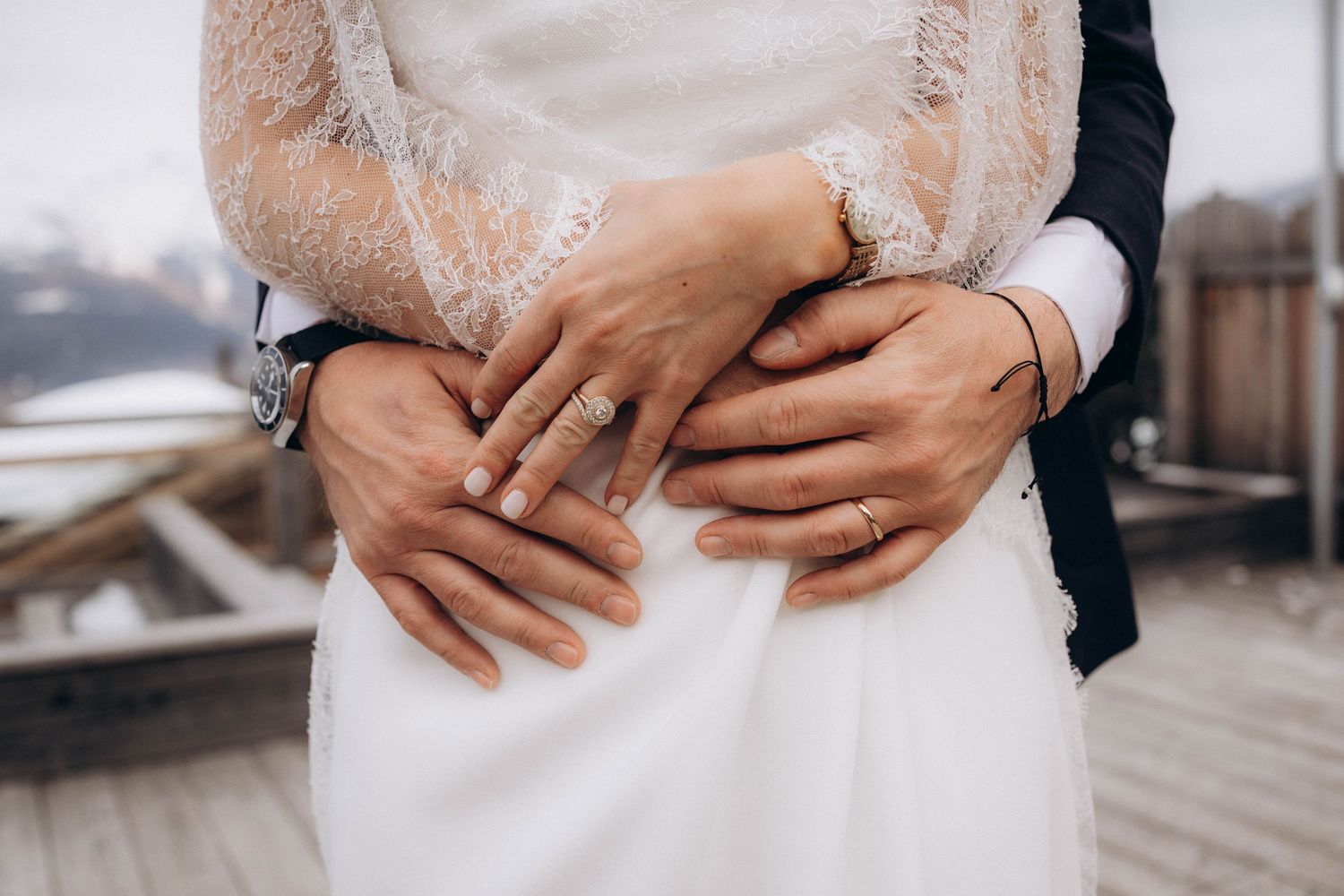 A romantic black and white wedding photograph showing a tender embrace in a natural outdoor setting.