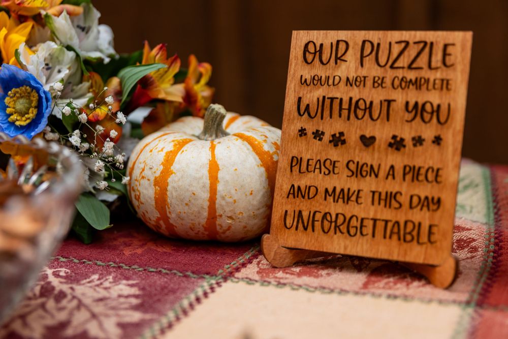 Wooden wedding guest book puzzle sign with pumpkins and fall flowers.