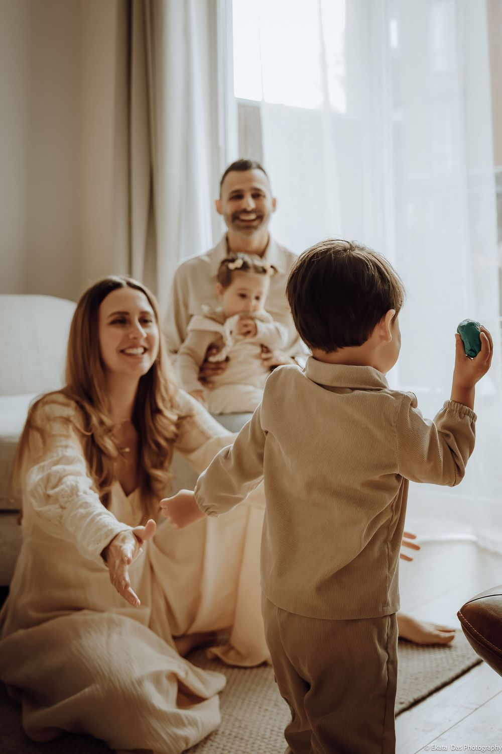 Family sharing joyful moment together in bright sunlit room.