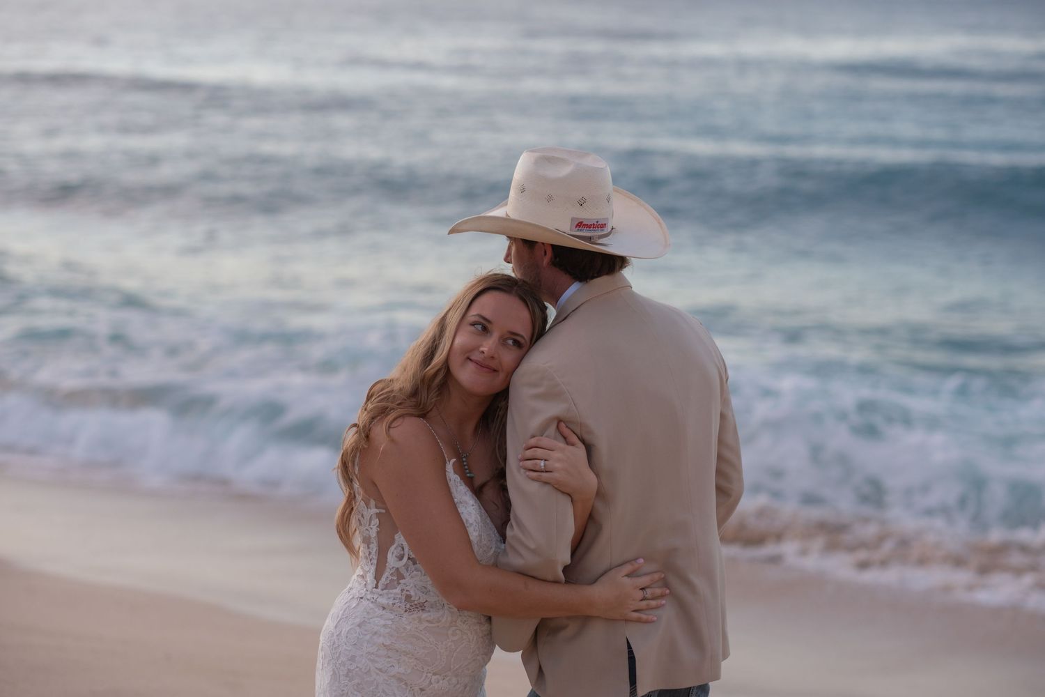 Couple embracing on the beach during a Hawaii elopement photography session at sunset.