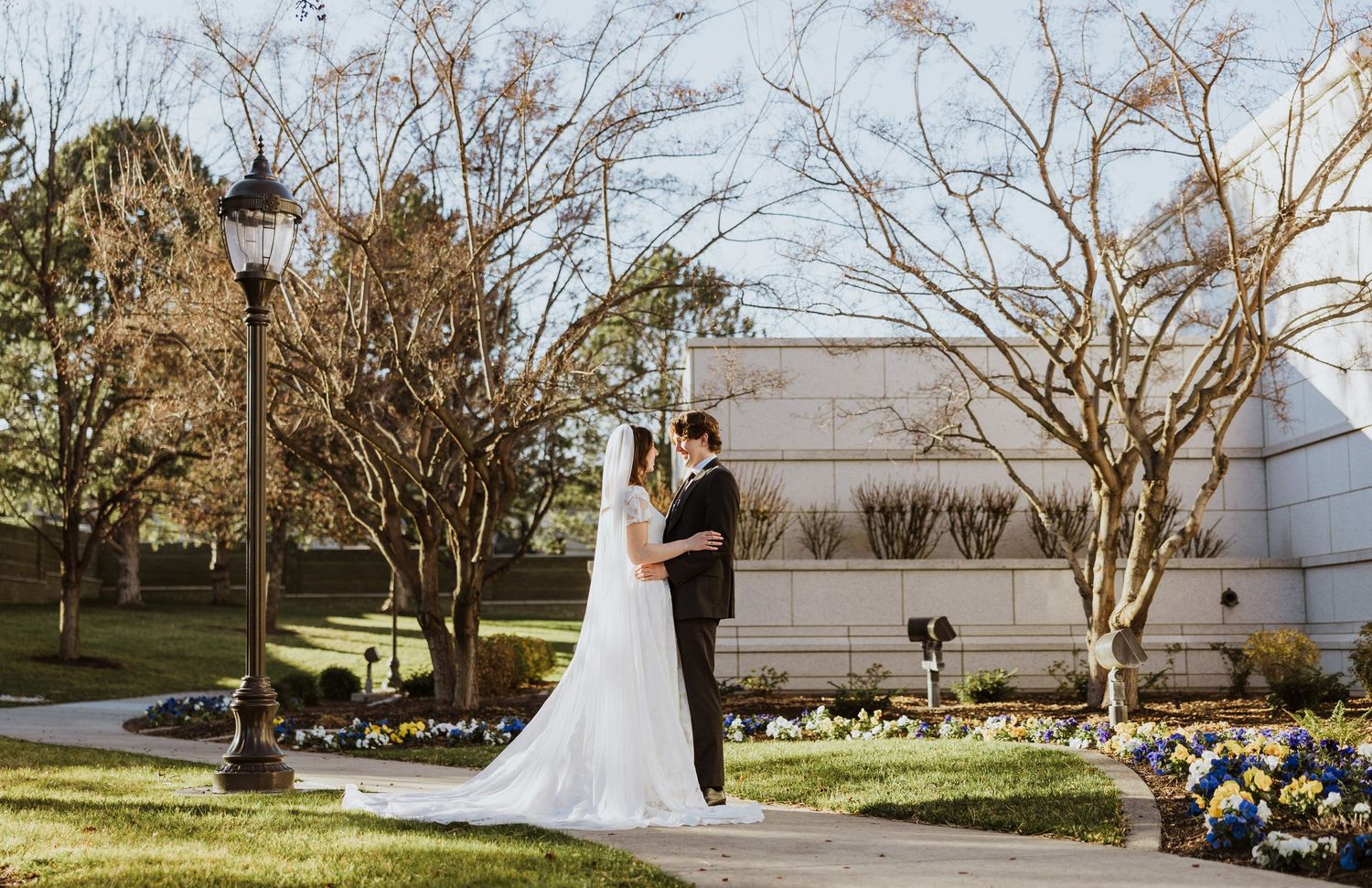 A wide shot of the bride and groom outside of the chapel surrounded by beautiful landscaping in tricities washington