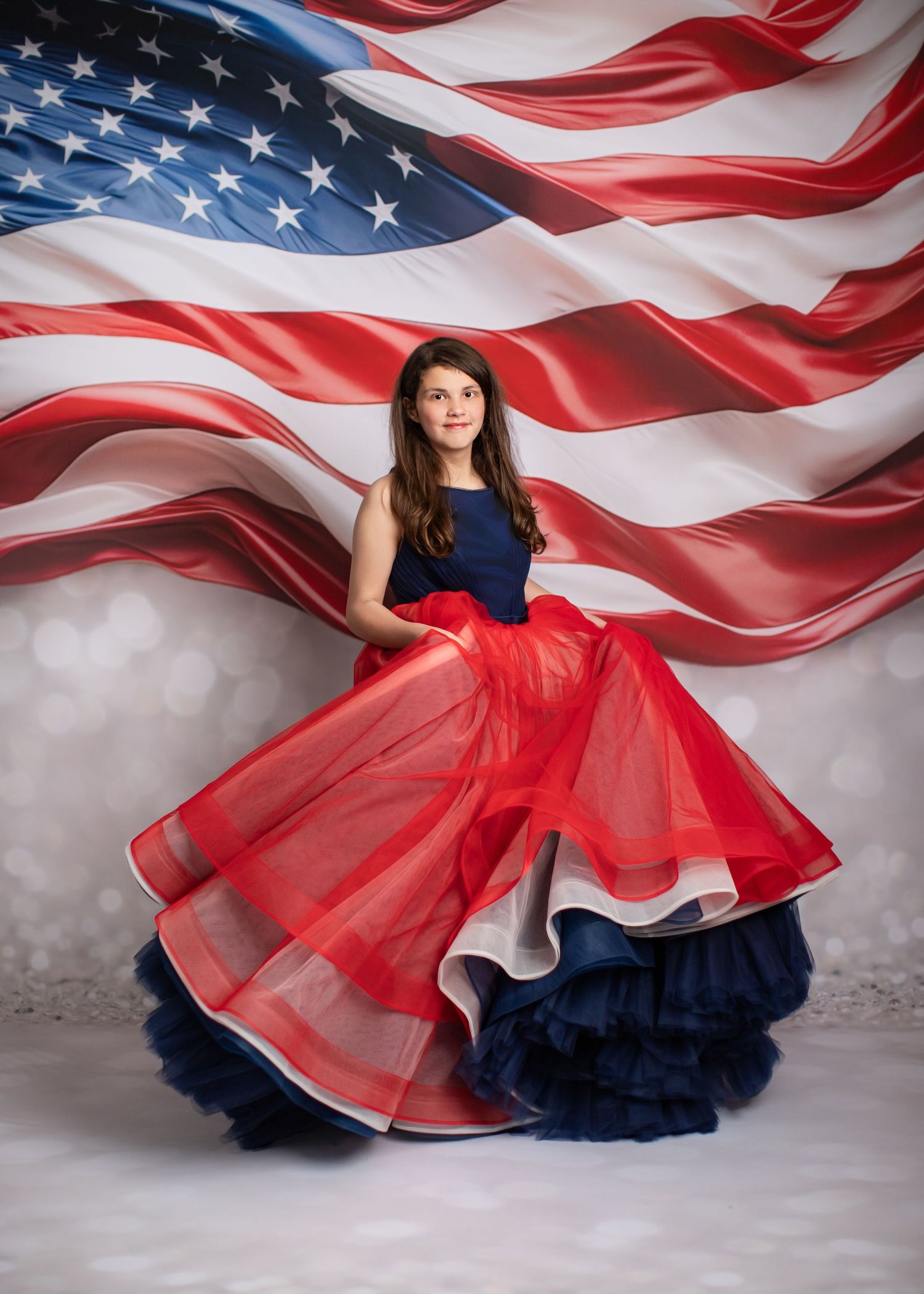 Elegant portrait in flowing deep purple ballgown against dramatic dark background.