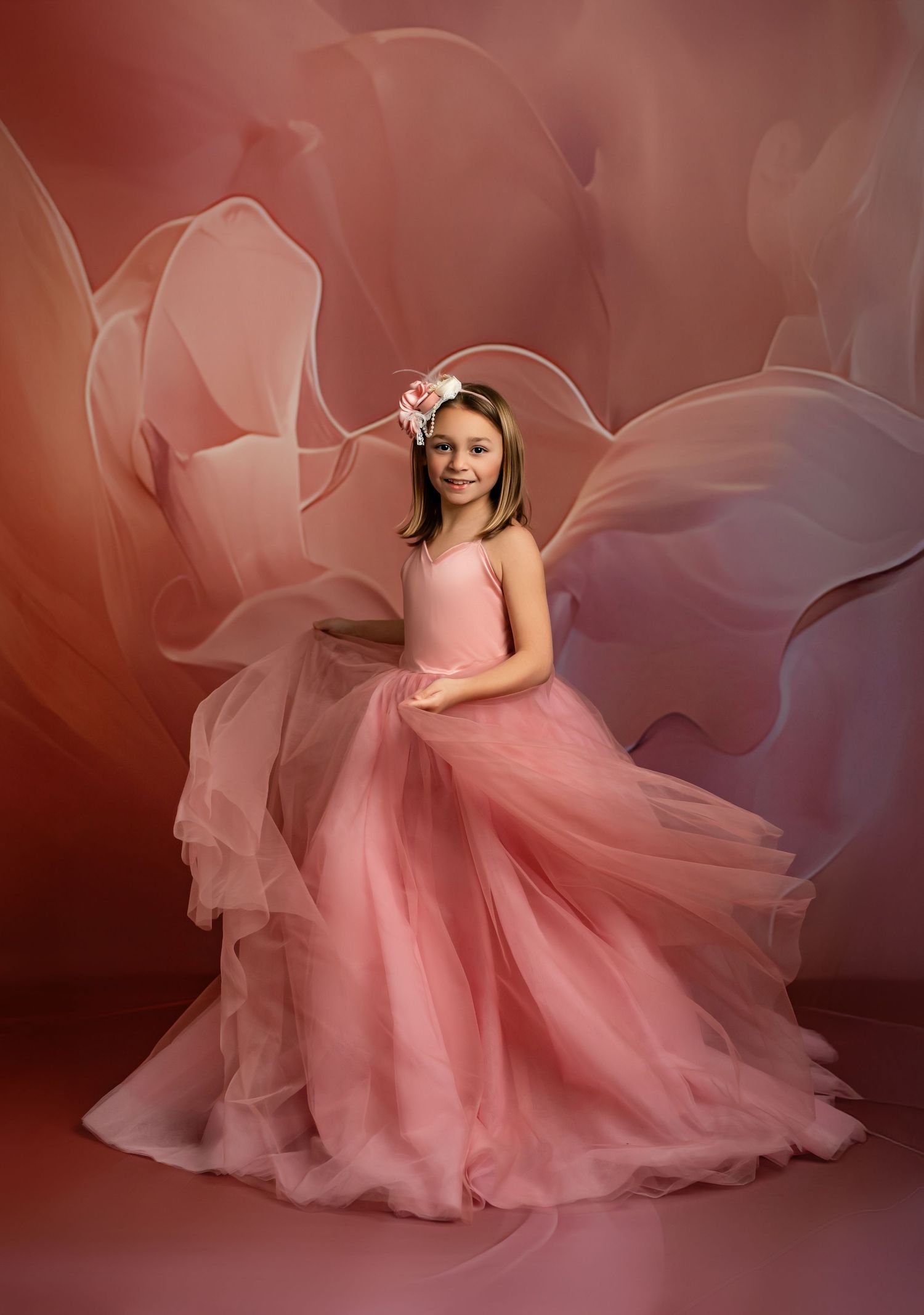 A bright red dress with puff sleeves and heart balloon photographed against a red studio backdrop.