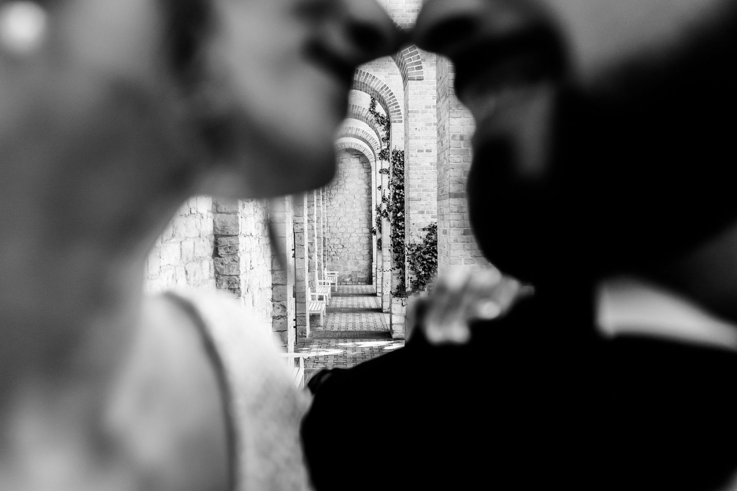 Creative black and white photograph showing stone archways through a figure's silhouette reflection.