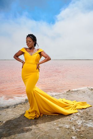 lady standing by a lake in a beautiful yellow dress