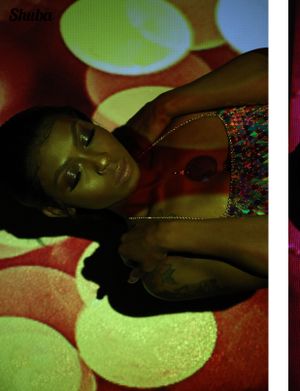 Artistic portrait shot with green circular light patterns in the background creating a moody atmosphere.