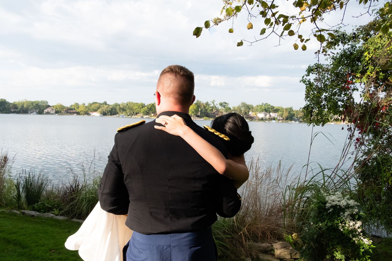 Husband holding his new bride while looking over a open lake