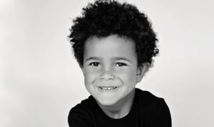 A black and white portrait showcasing a bright, cheerful expression.