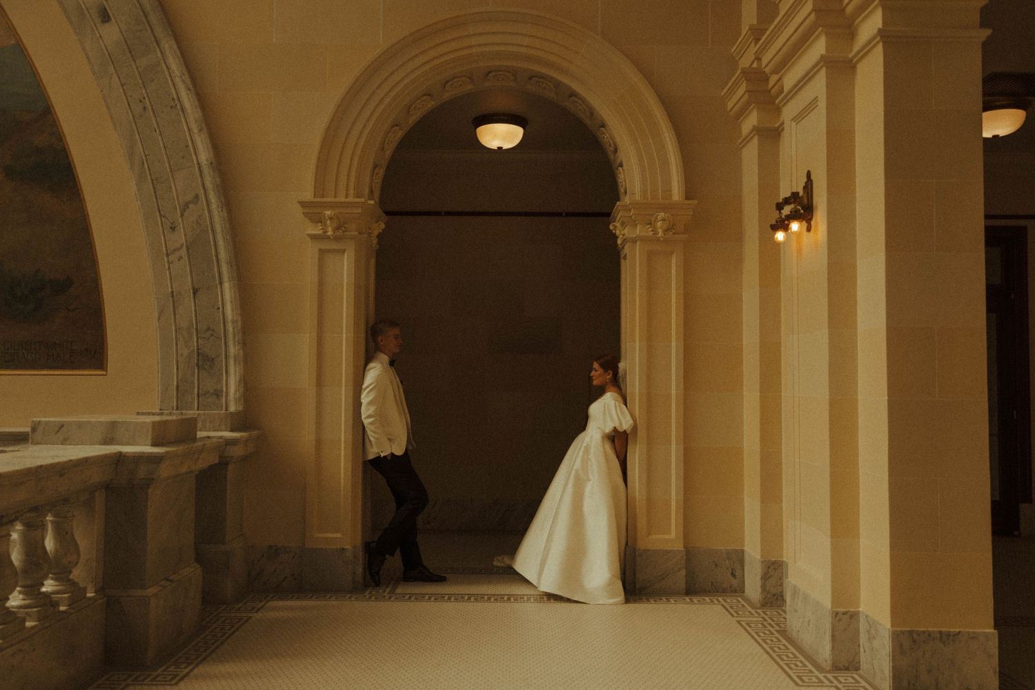 Elegant arched hallway with cream colored walls and classical architectural details.