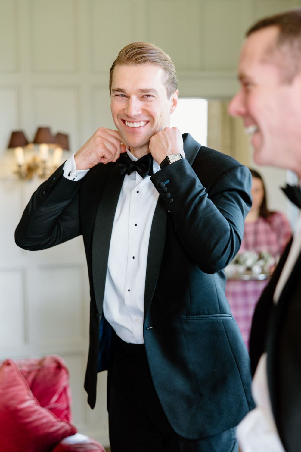 A formal event preparation scene with participants adjusting bow ties.