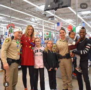 Group photo with police officers and civilians posing together inside a retail store during holiday season.