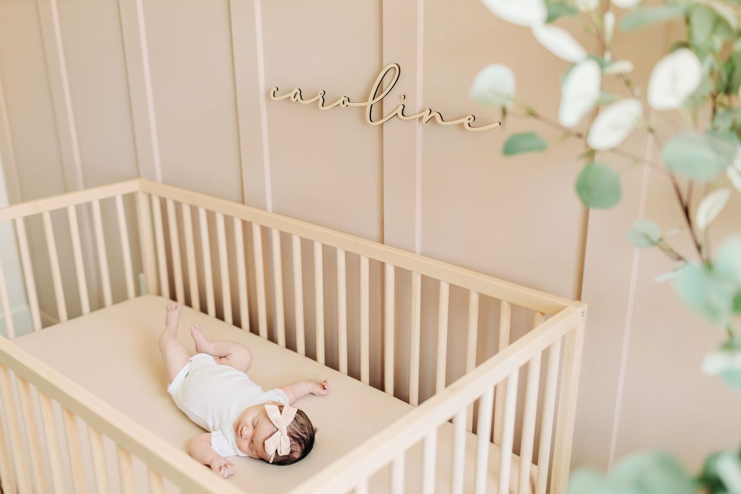 Newborn baby laying in a pastel crib