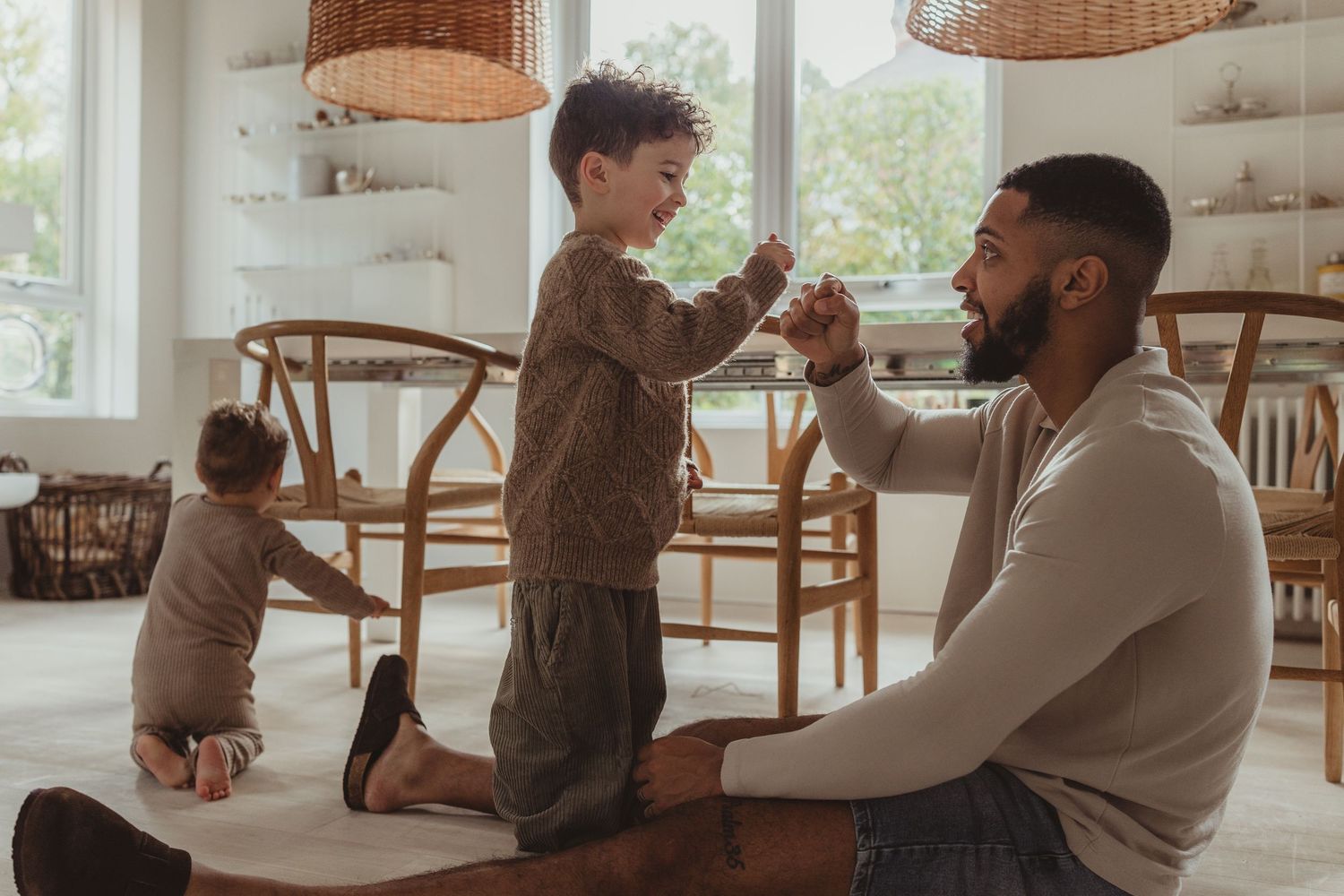 A joyful moment shared between a parent and child laughing together while sitting indoors.