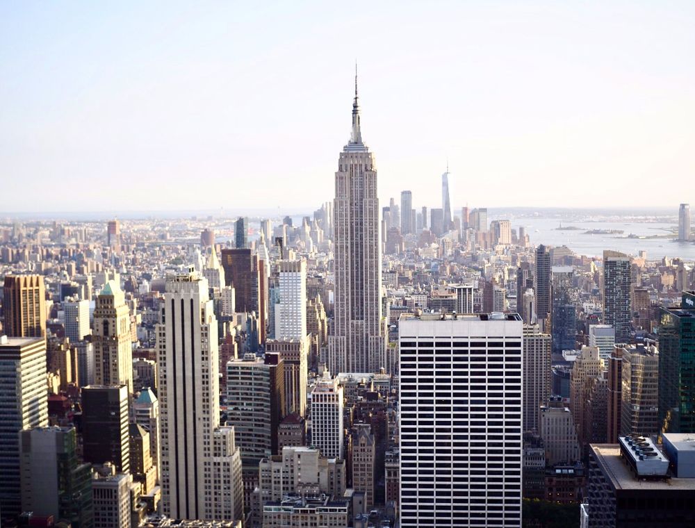 Aerial view of New York City skyline featuring the iconic Empire State Building on a clear day.