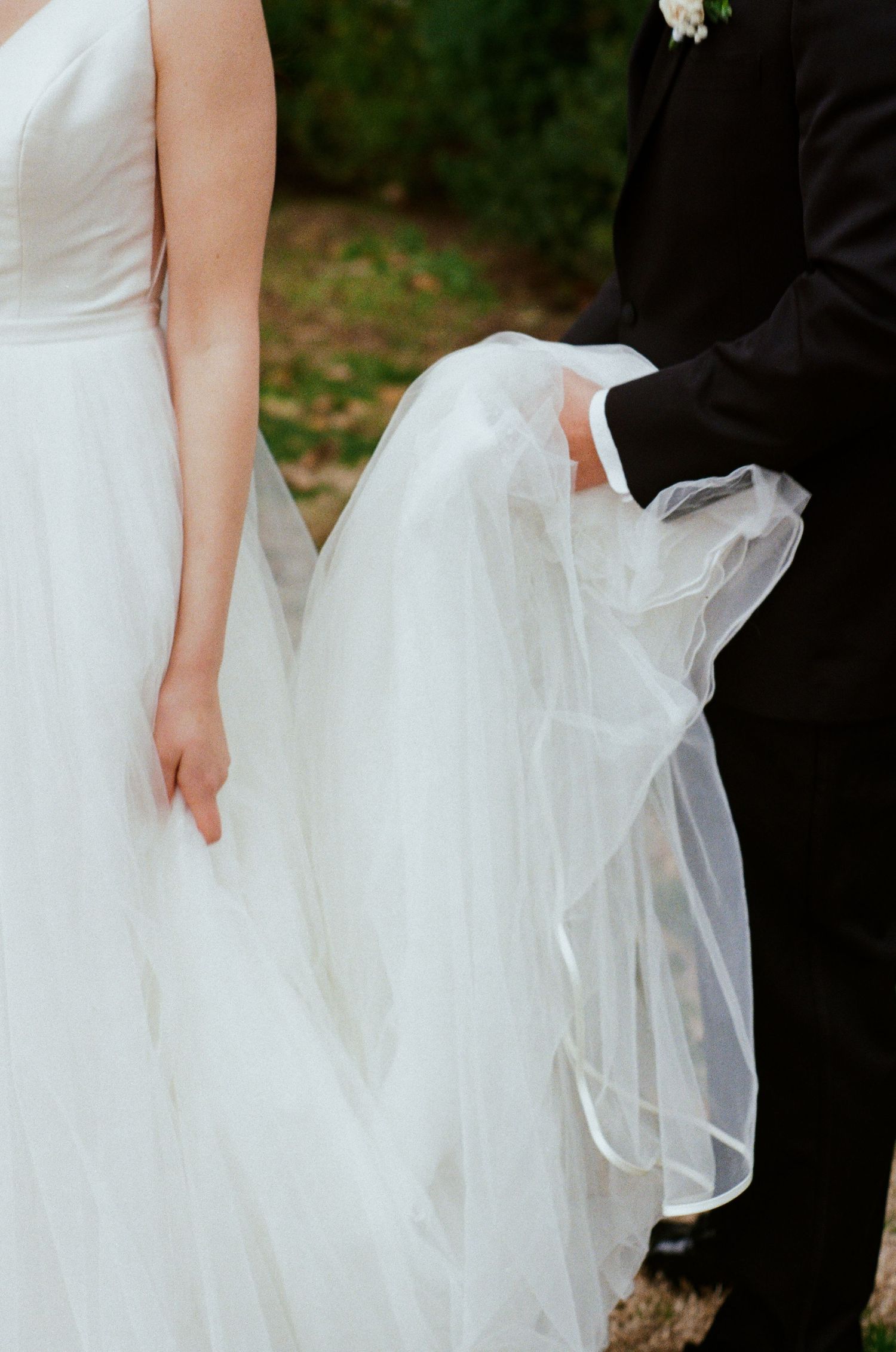 groom holding bride's dress