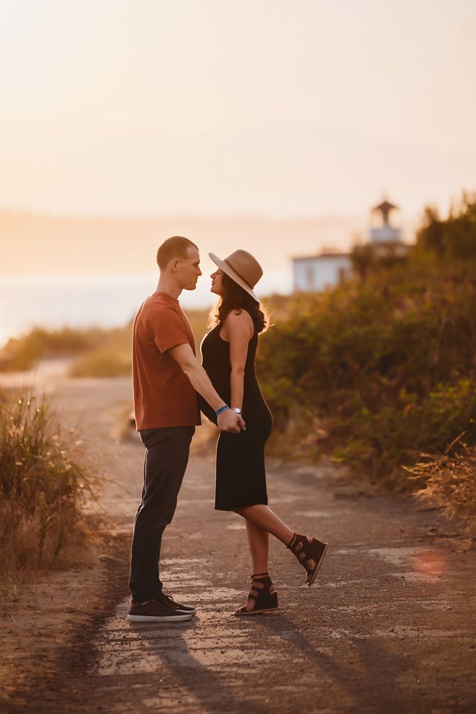 A romantic sunset moment between a couple on a coastal path.