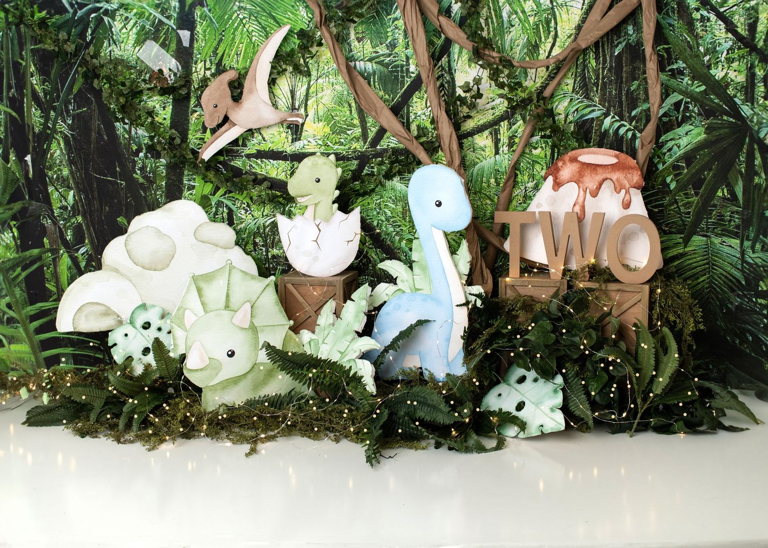 dinosaur Woodland forest first birthday cake smash setup with greenery and florals in Linden, New Jersey.