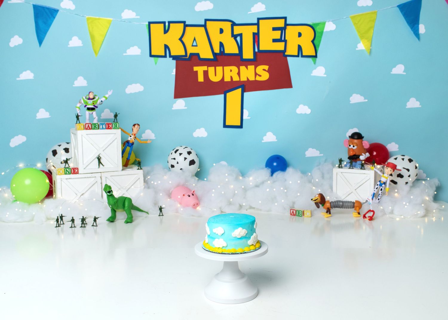 Toy story themed Colorful custom first birthday cake smash setup with blue background and balloons in Linden, New Jersey.