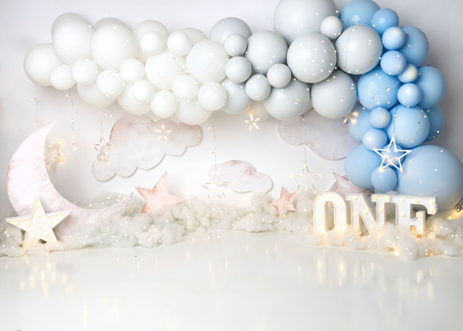Blue and white cloud themed first birthday cake smash setup in a Linden, New Jersey studio.