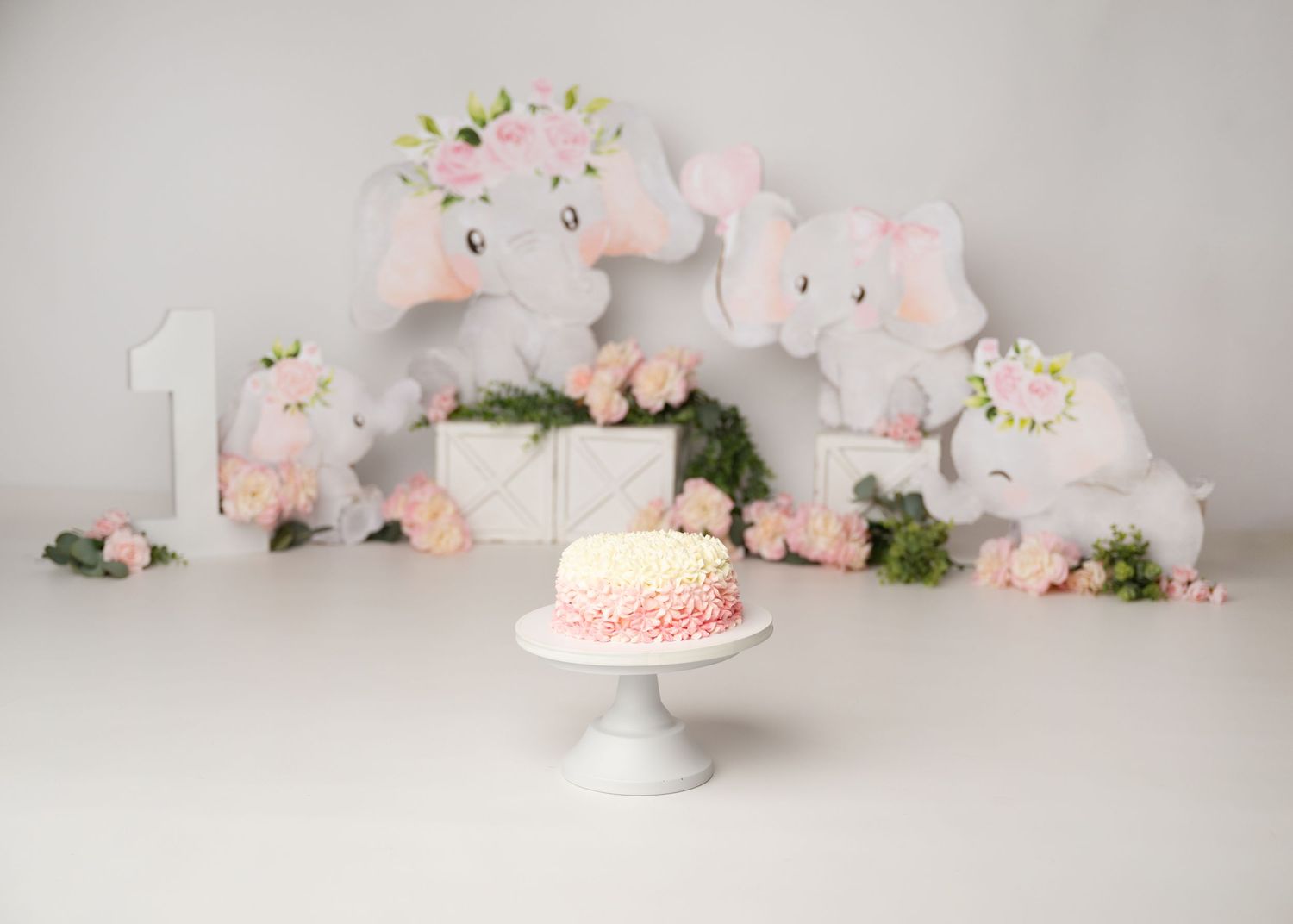 Blush pink floral first birthday cake smash setup with soft flowers and balloons in Linden, New Jersey.