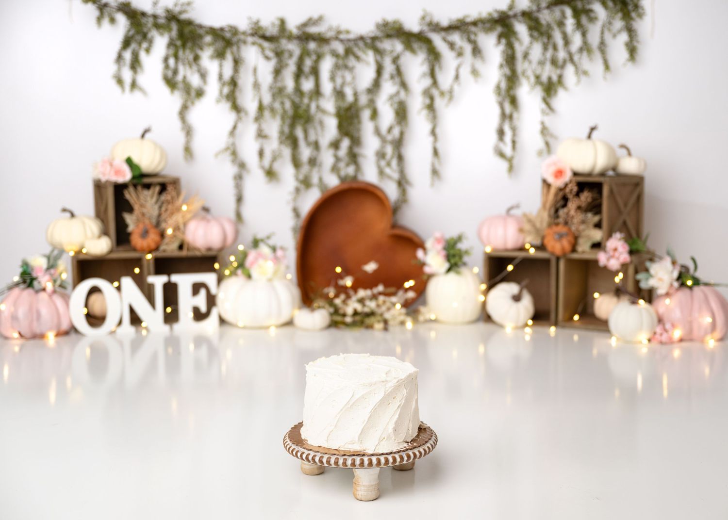 Boho peach and cream first birthday cake smash setup with neutral balloons in Linden, New Jersey.