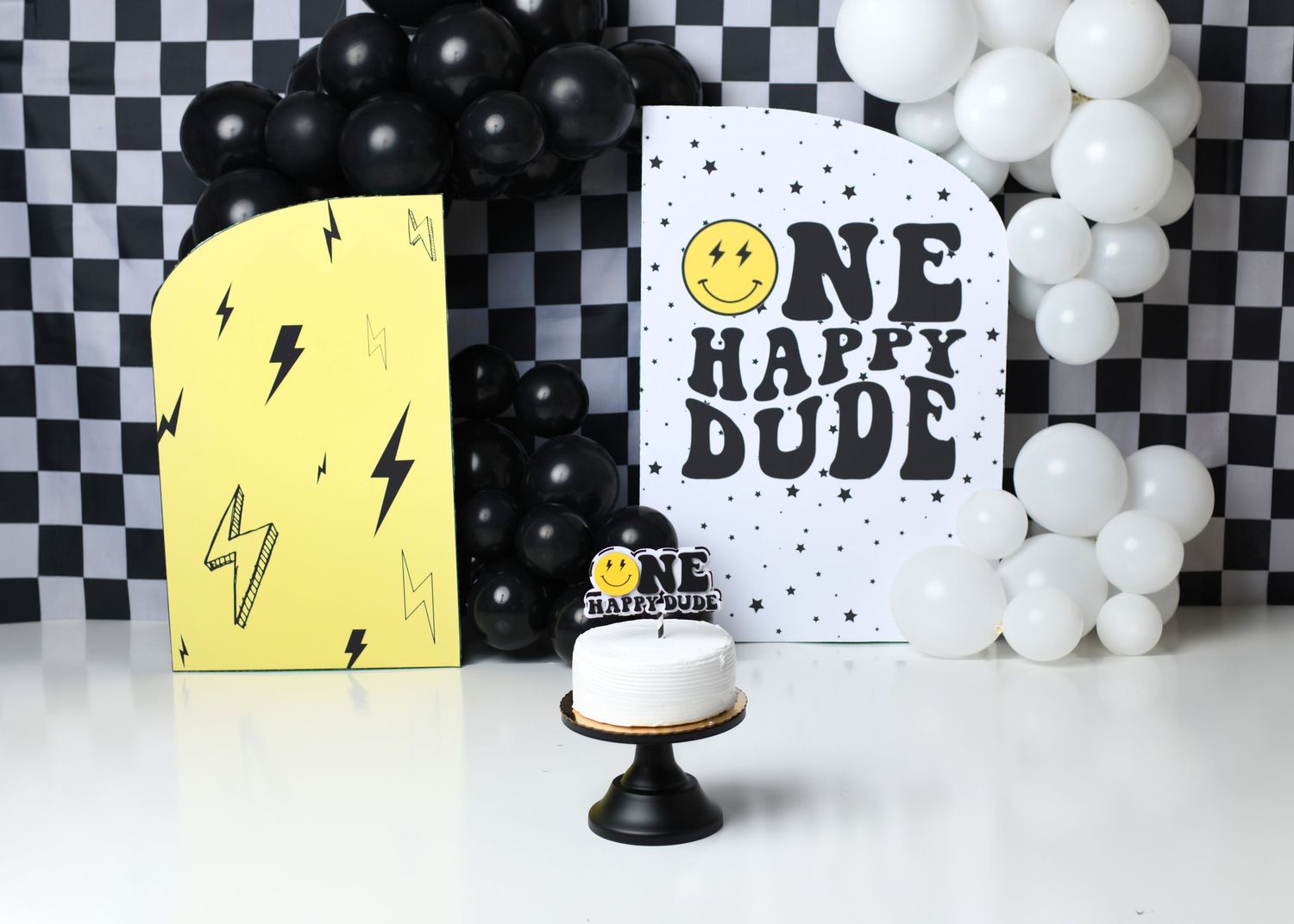 "One Happy Dude” first birthday setup with black, white, and yellow decor.