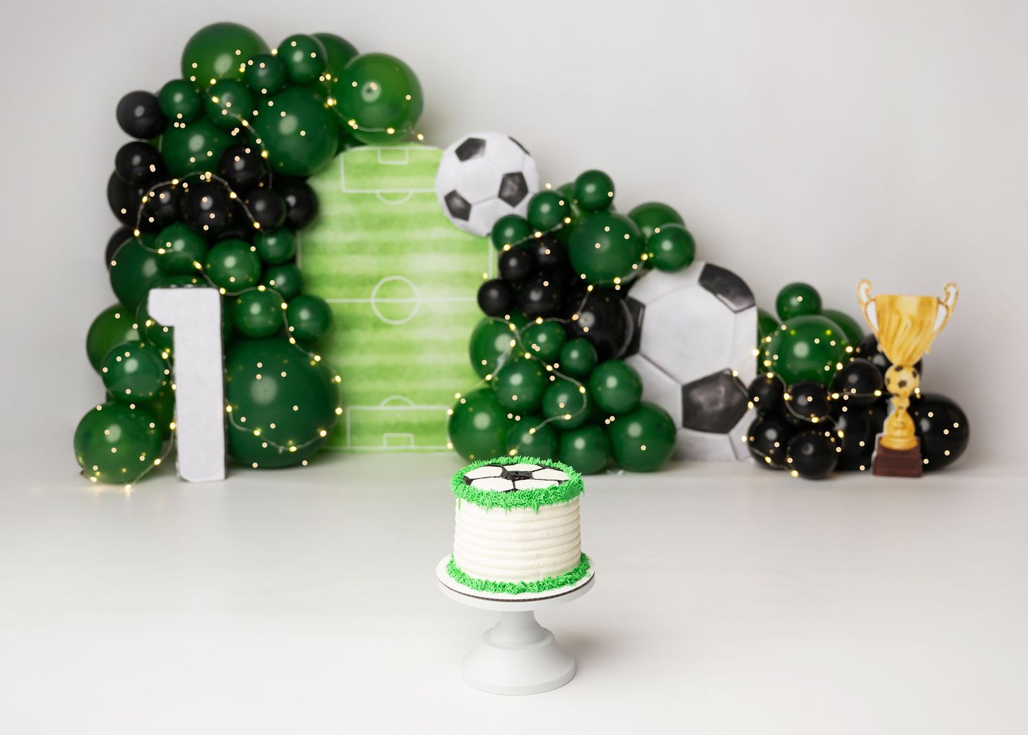 Green first birthday cake smash setup with playful themed decor in Linden, New Jersey.