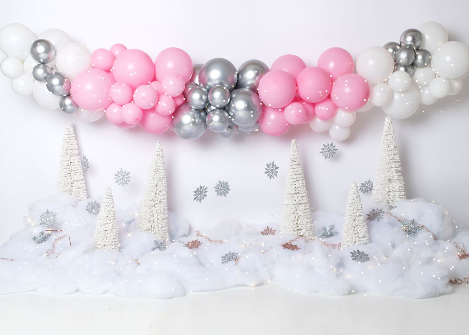 Pink and silver first birthday cake smash setup with balloon garland in Linden, New Jersey.
