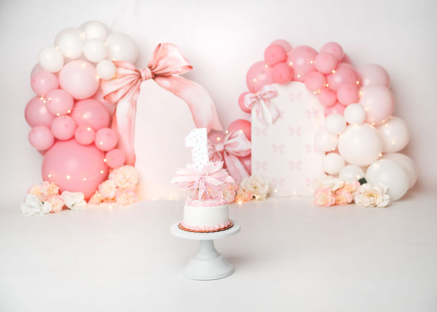 Soft pink first birthday cake smash setup with balloon arches in Linden, New Jersey.