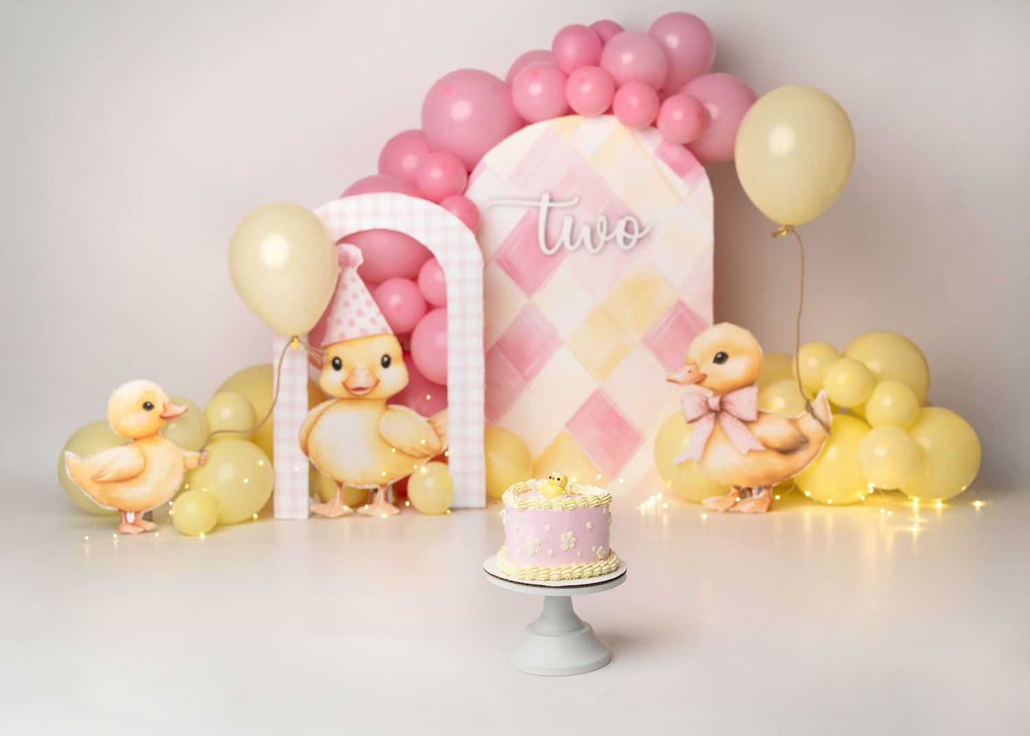 Ducks Pink and gold first birthday cake smash setup with balloon arch in Linden, New Jersey.