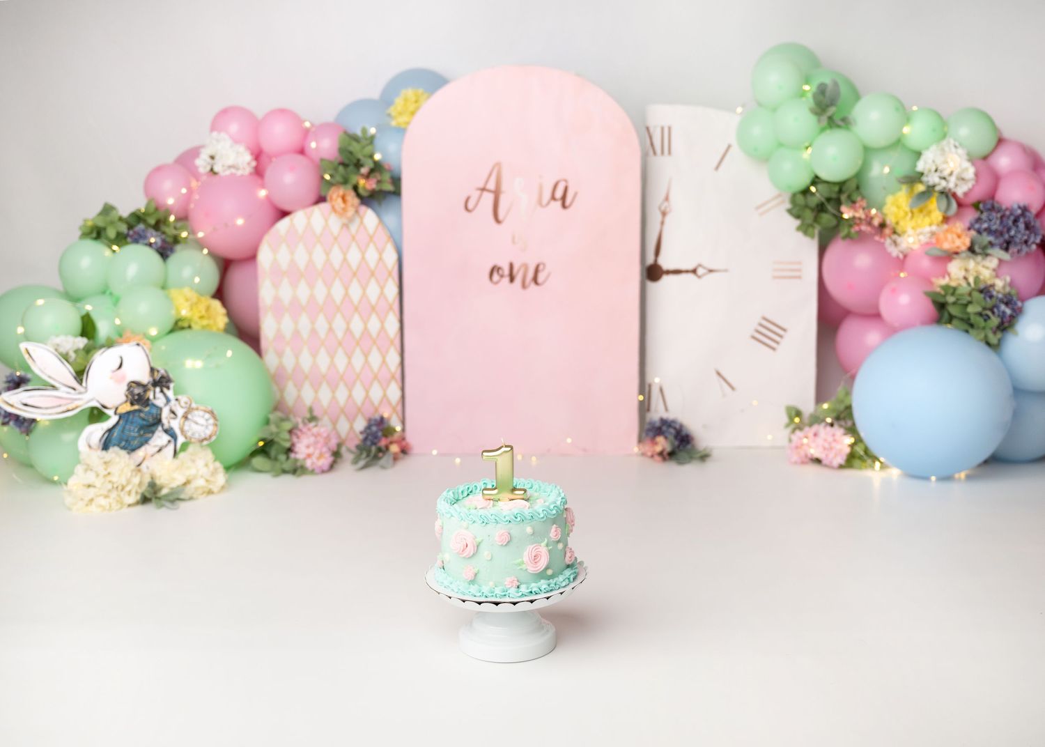Pastel floral first birthday cake smash setup with pink and green decor in Linden, New Jersey.