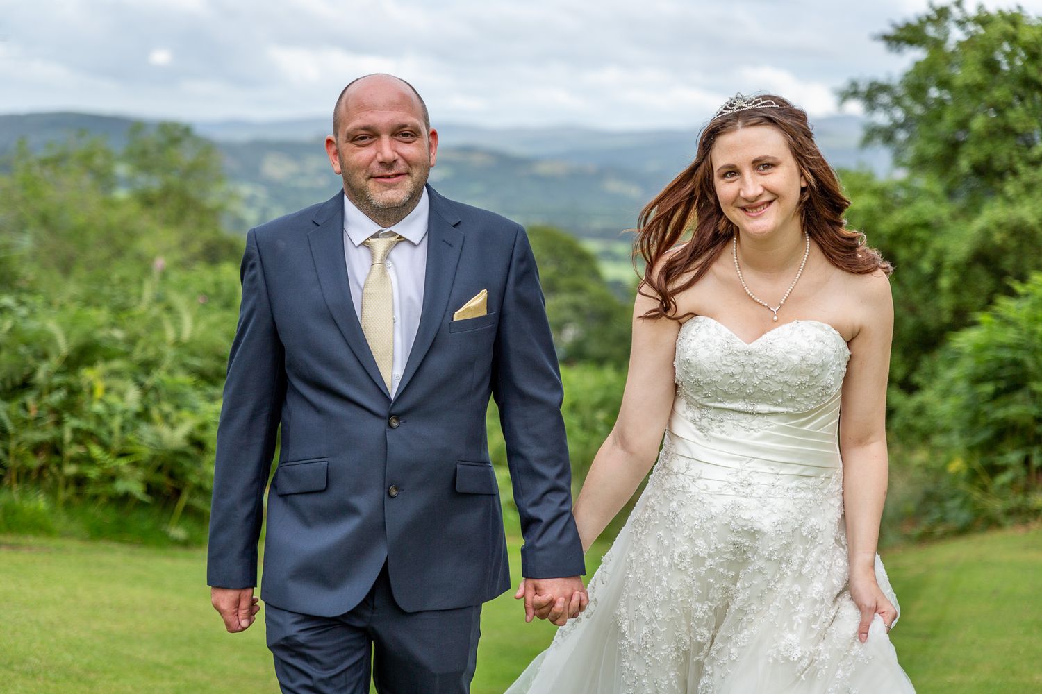 A couple walking across the lawn at their wedding reception. Gwynedd wedding photographer. Bala wedding.