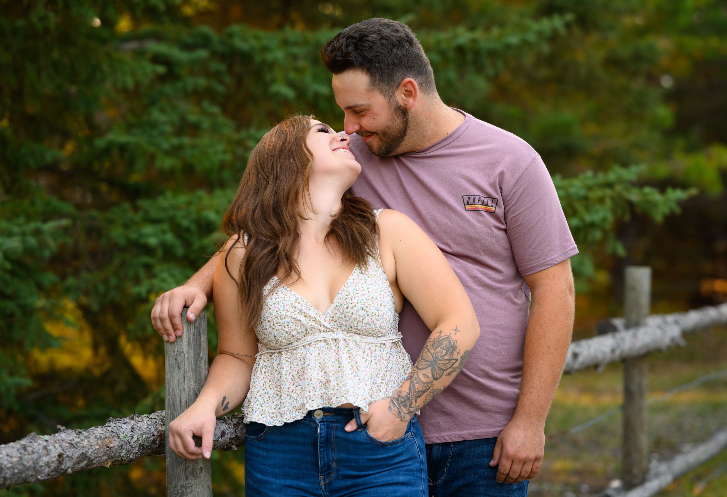 A loving couple sharing a joyful moment together outdoors with natural greenery in the background.