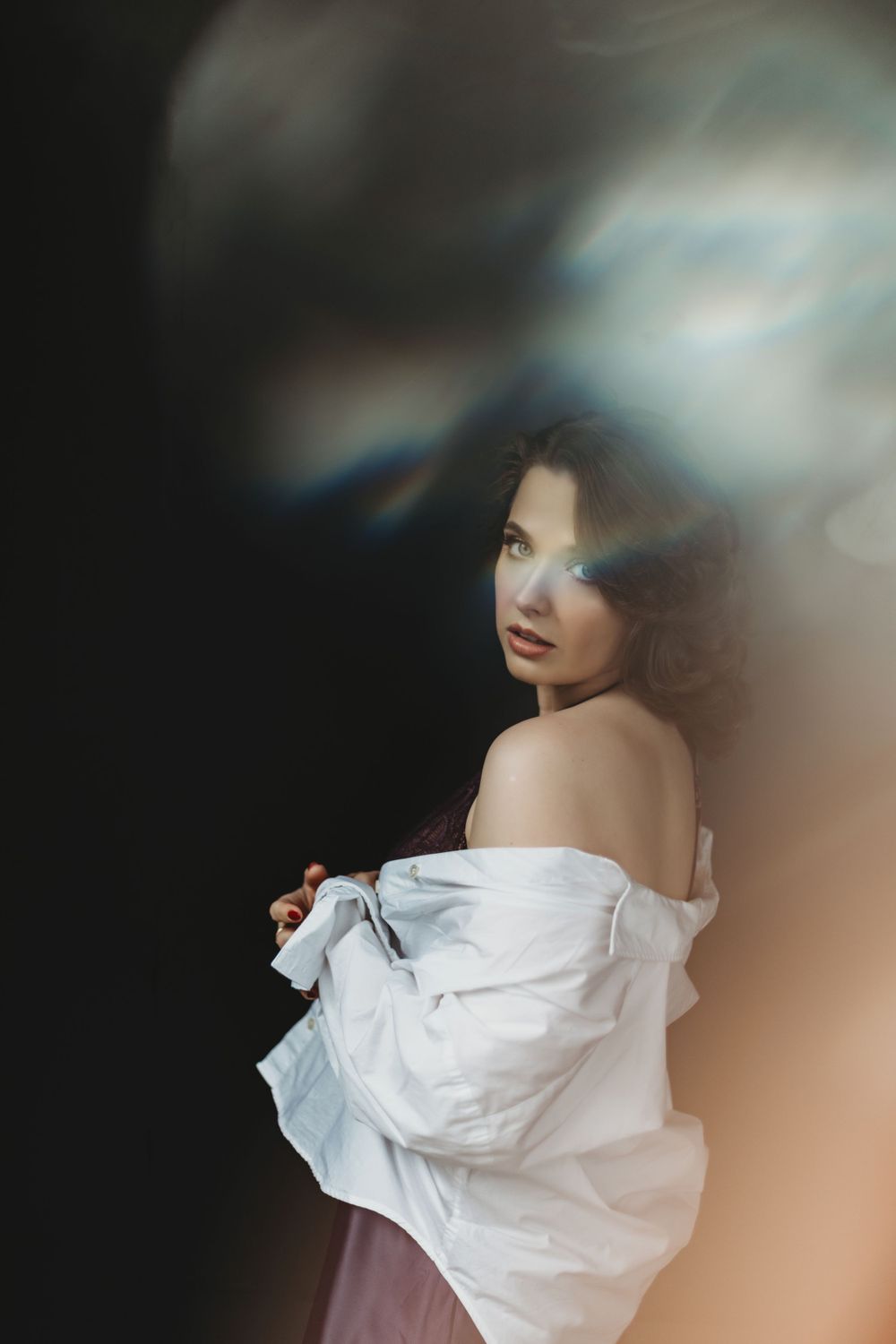 Artistic portrait photo showing ethereal mood with white flowing fabric and soft focus blurred edges  in Bellevue studio.